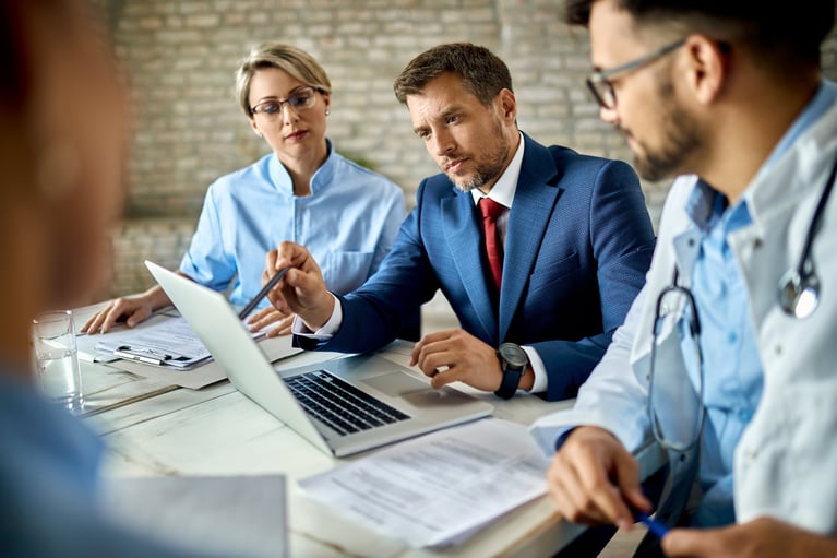 mid-adult-businessman-group-doctors-working-computer-meeting
